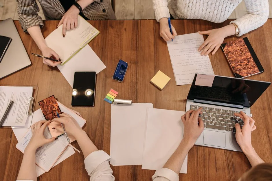 Three women in hijabs collaborating on digital advertising strategies around a table with laptops.